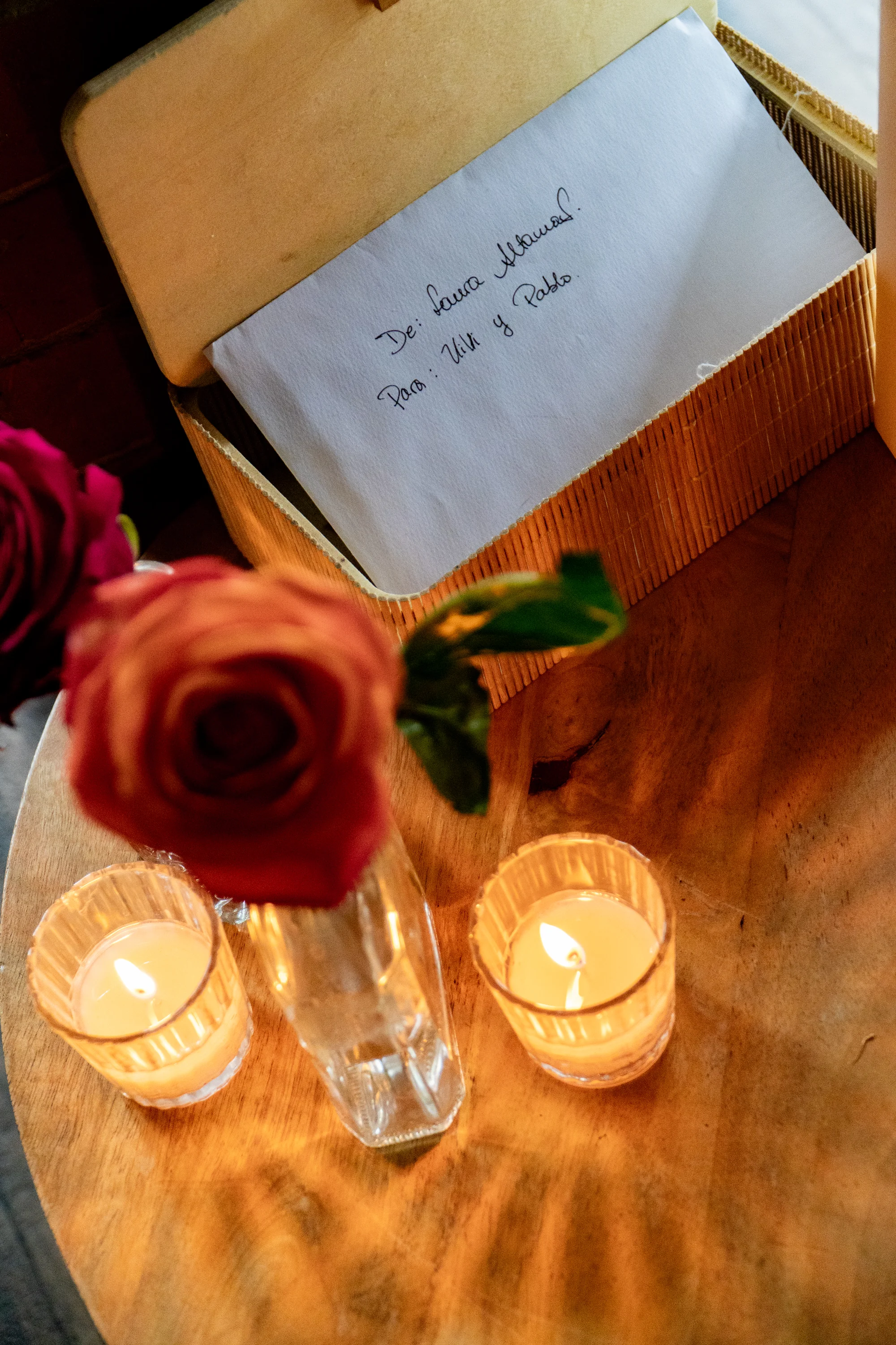 Detalle de rosa, velas y carta sobre la mesa — Luréa Studio