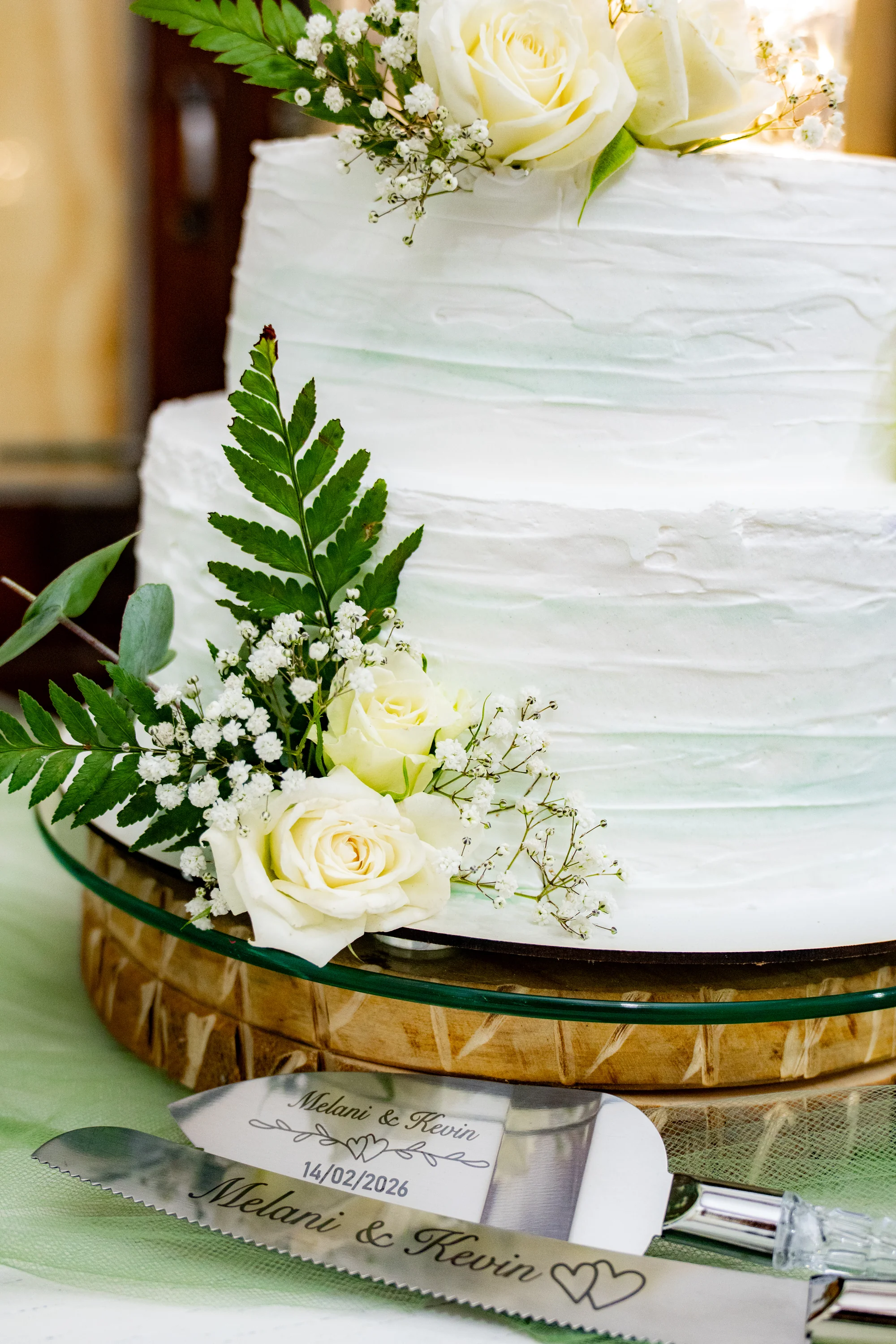 Torta de boda blanca con flores sobre mesa dorada — Luréa Studio