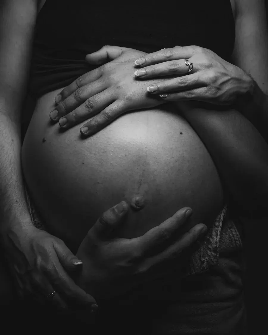 Manos entrelazadas sobre la panza