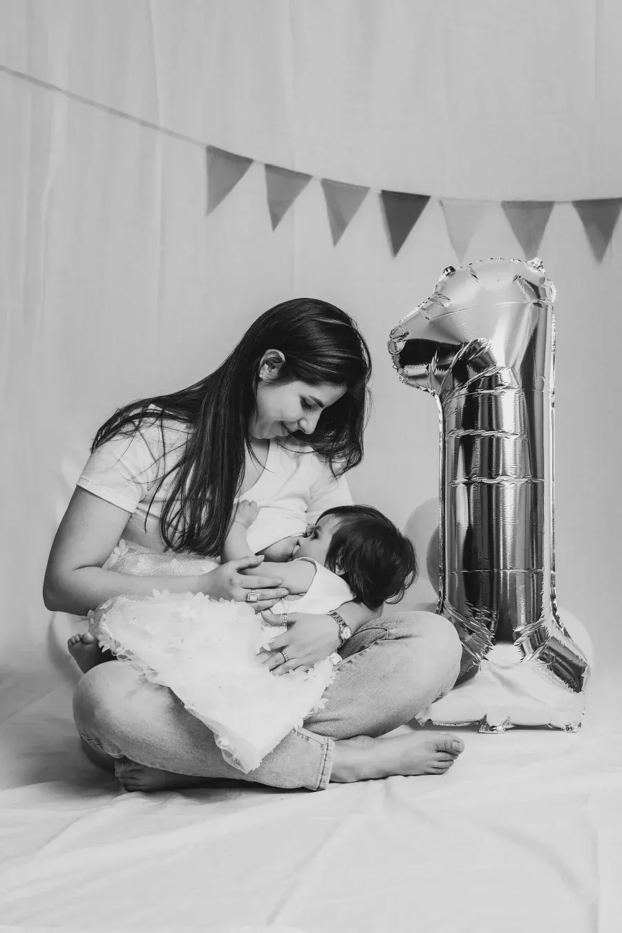 Mamá con su bebé junto a un globo de número uno