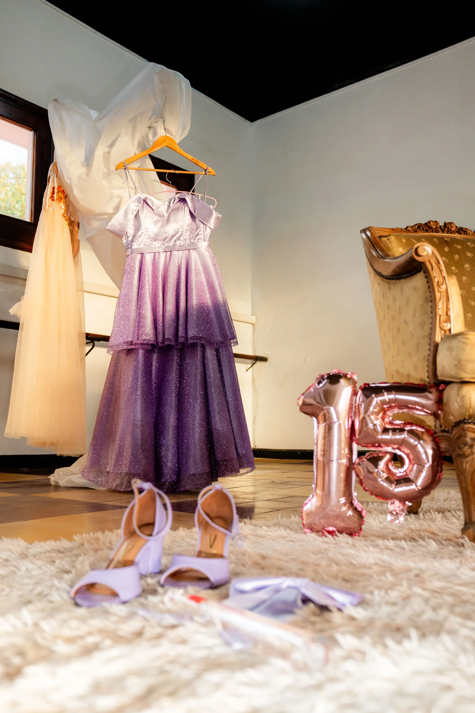 Quinceañera con vestido rosa en una escalinata iluminada 17